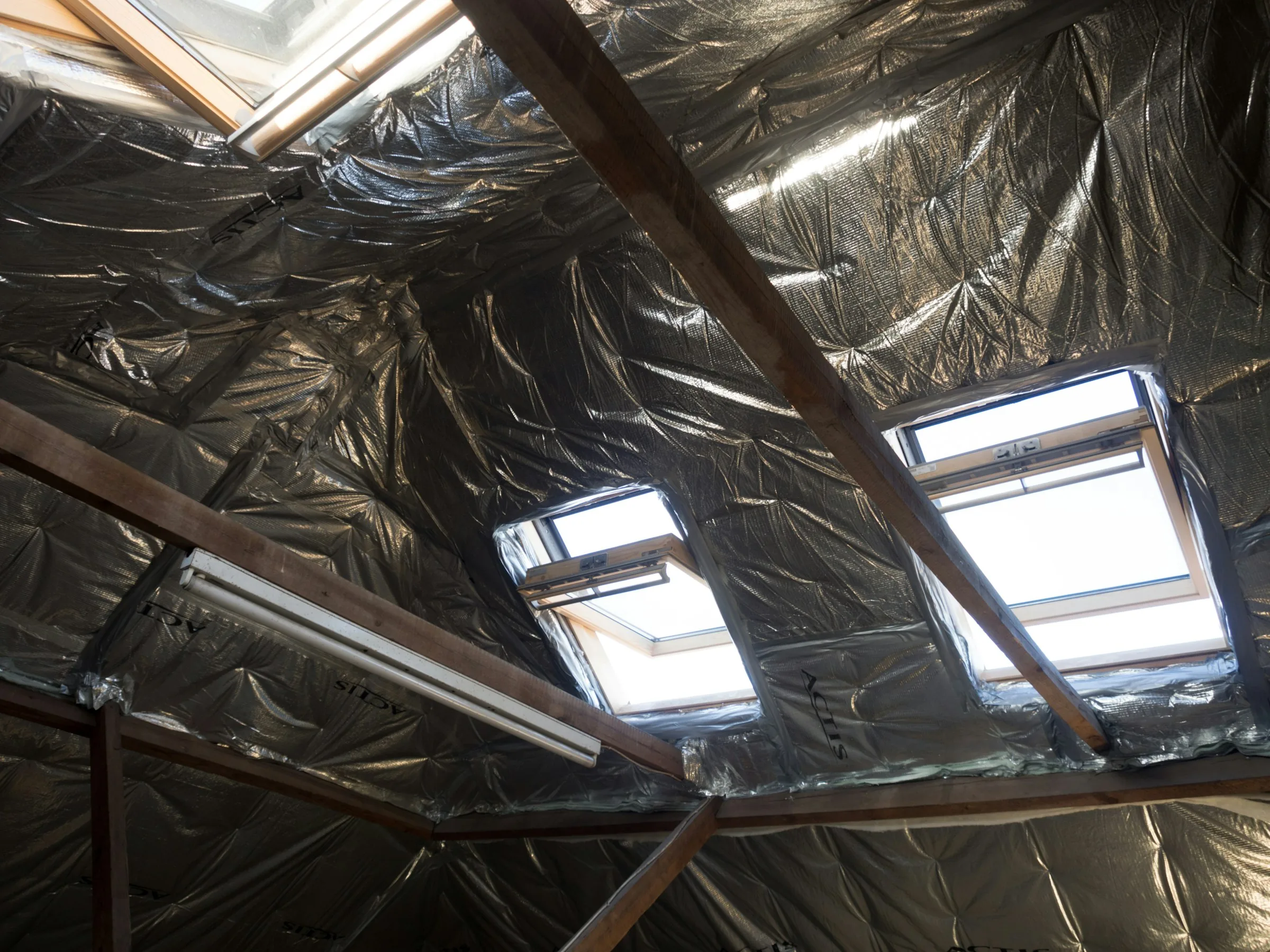 Professional attic insulation installed beneath skylights